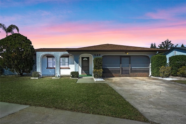 single story home with a garage and a yard