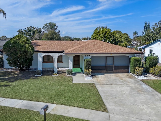 ranch-style home with a garage and a front lawn