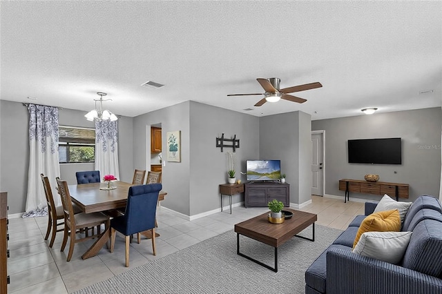 tiled living room with ceiling fan with notable chandelier and a textured ceiling