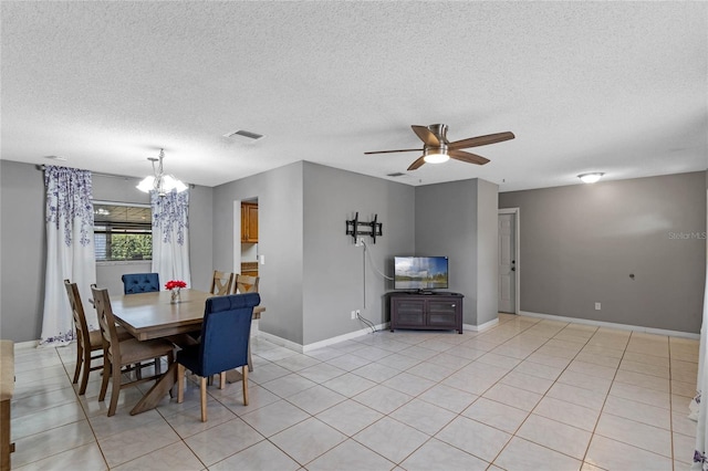 dining room featuring light tile patterned floors, ceiling fan with notable chandelier, and a textured ceiling