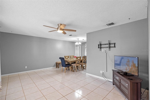 interior space featuring ceiling fan with notable chandelier, a textured ceiling, and light tile patterned floors