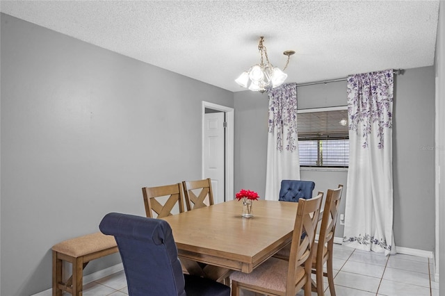 dining room featuring an inviting chandelier, a textured ceiling, and light tile patterned flooring