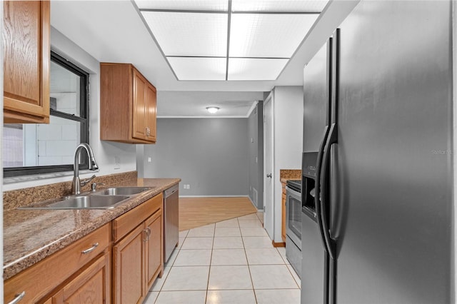 kitchen with stainless steel appliances, sink, and light tile patterned floors