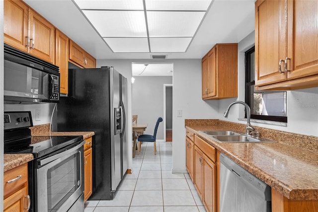 kitchen with stainless steel appliances, sink, and light tile patterned floors