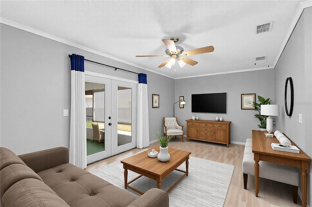 living room with crown molding, ceiling fan, light hardwood / wood-style floors, and french doors