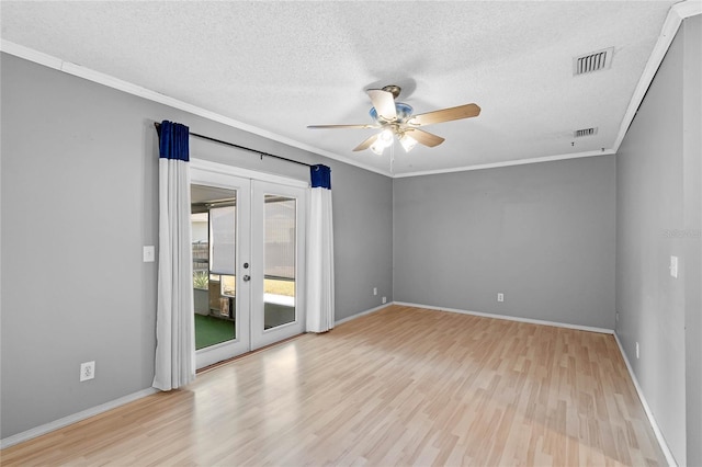 spare room featuring crown molding, light hardwood / wood-style flooring, a textured ceiling, and french doors