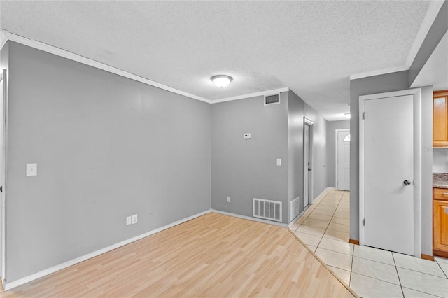 unfurnished room featuring crown molding, a textured ceiling, and light hardwood / wood-style flooring