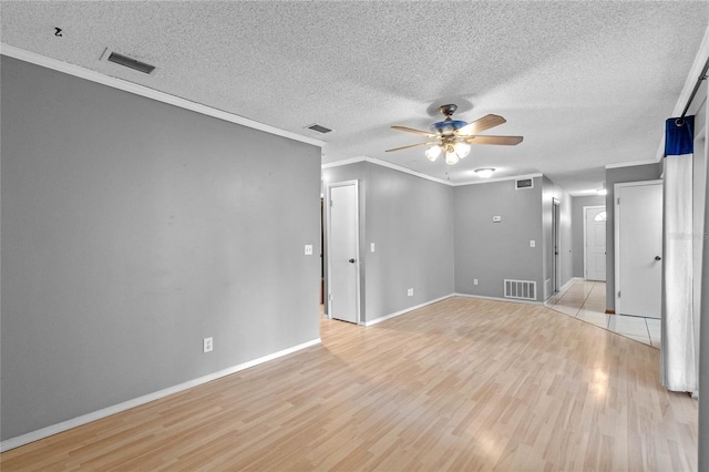 spare room featuring crown molding, light hardwood / wood-style floors, ceiling fan, and a textured ceiling