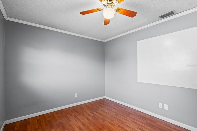 empty room with hardwood / wood-style flooring, ornamental molding, ceiling fan, and a textured ceiling