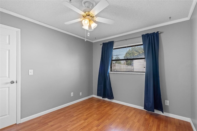 spare room with hardwood / wood-style floors, a textured ceiling, ornamental molding, and ceiling fan