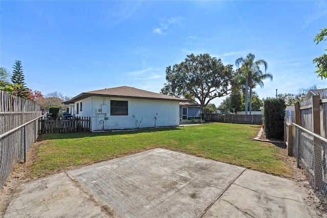 rear view of property featuring a patio area and a lawn