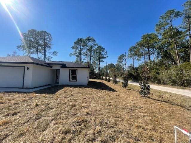 view of side of property with a garage and a yard