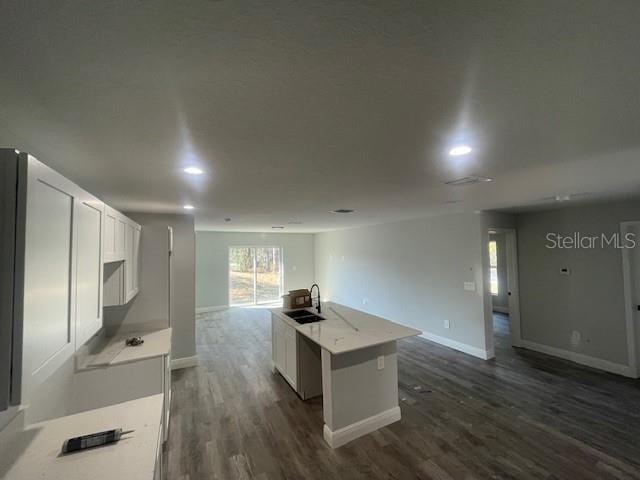 kitchen featuring white cabinetry, a kitchen island with sink, sink, and dark hardwood / wood-style flooring