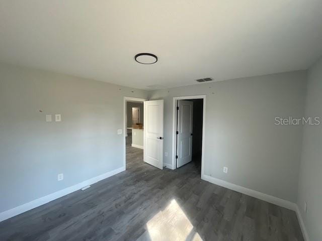 spare room featuring dark wood-type flooring