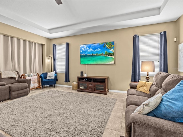 tiled living room featuring a raised ceiling