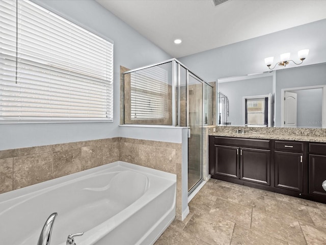 bathroom with independent shower and bath, vanity, and a wealth of natural light