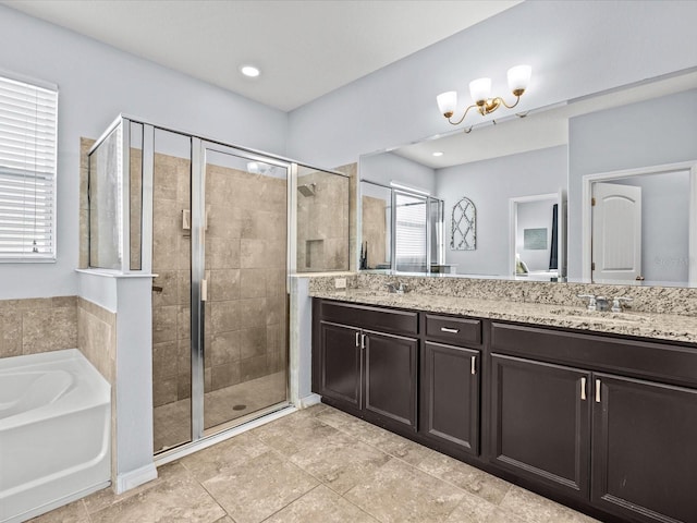 bathroom with an inviting chandelier, vanity, and separate shower and tub