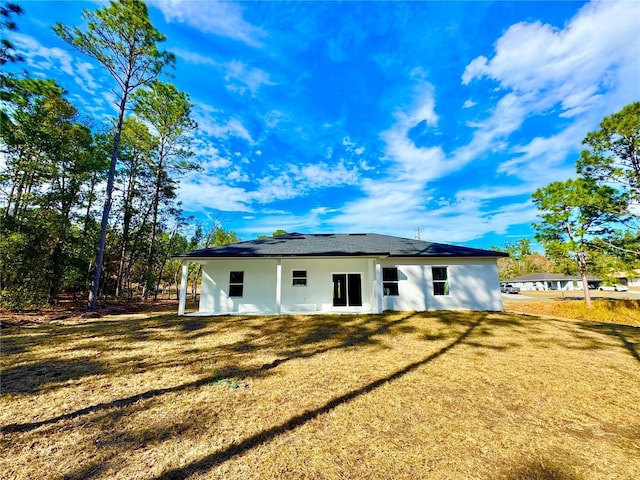 rear view of property featuring a lawn