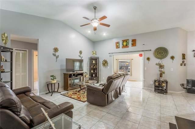 living room featuring light tile patterned flooring, vaulted ceiling, a wood stove, and ceiling fan