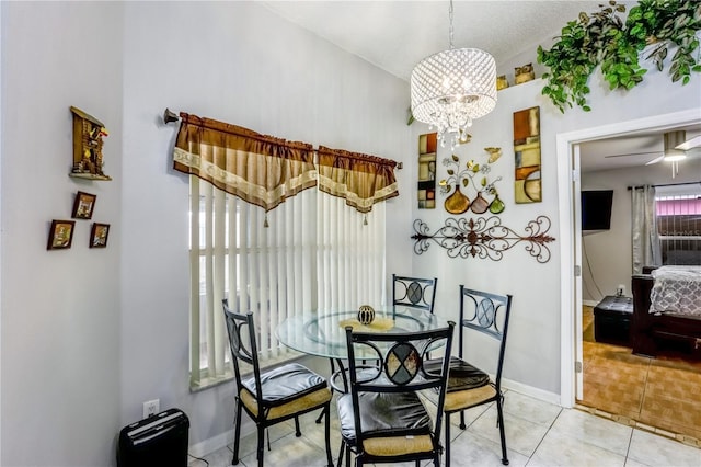 dining space with light tile patterned flooring and ceiling fan with notable chandelier