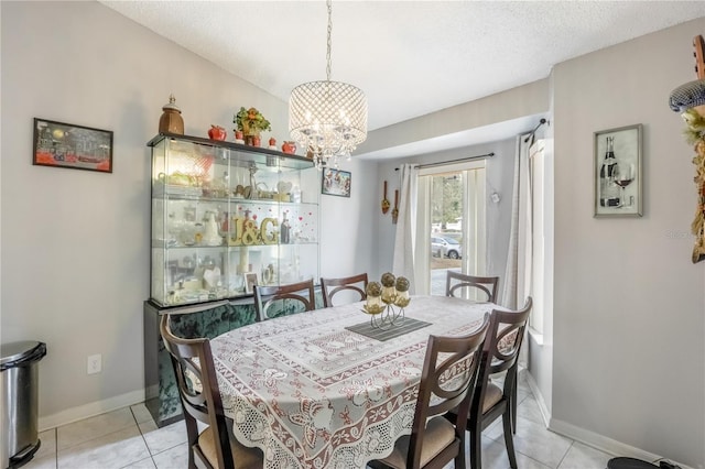 dining room featuring light tile patterned floors, a textured ceiling, and a chandelier