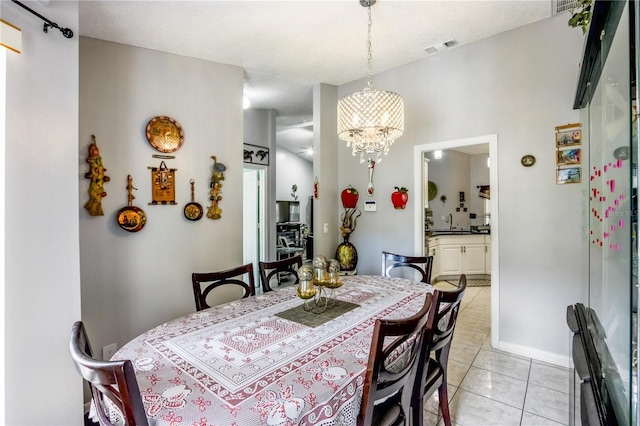 dining space with light tile patterned floors and a notable chandelier