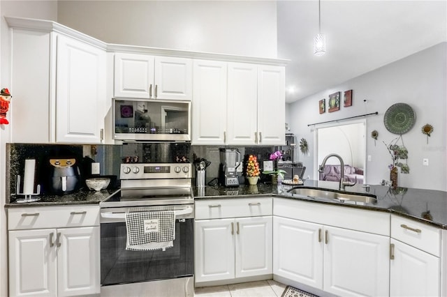 kitchen featuring sink, dark stone counters, white cabinets, stainless steel appliances, and backsplash