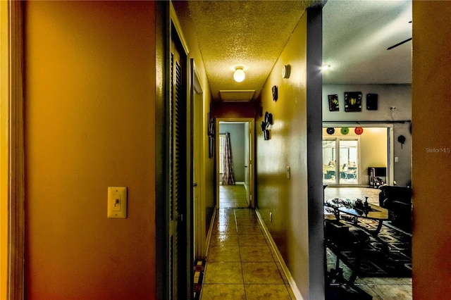 hall with tile patterned flooring and a textured ceiling