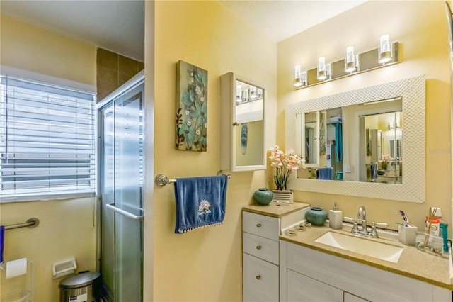 bathroom featuring vanity and a shower with door