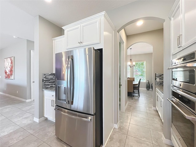 kitchen featuring stainless steel appliances, light stone countertops, and white cabinets