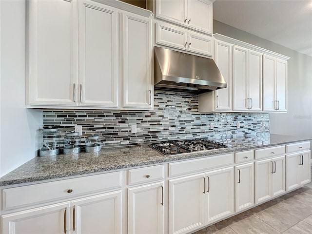 kitchen featuring stainless steel gas stovetop, white cabinetry, stone countertops, and backsplash