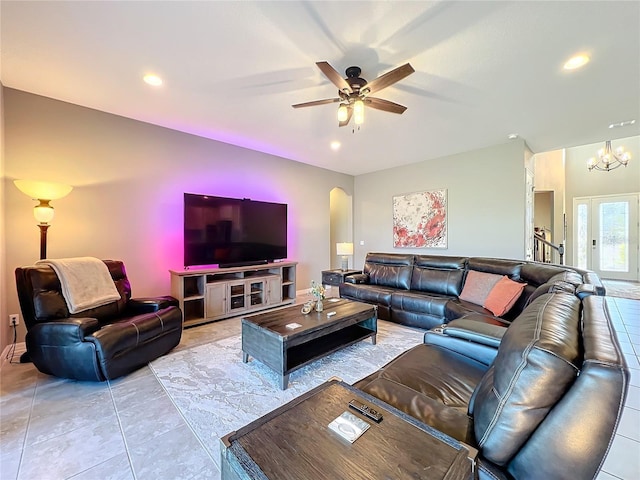 living room featuring ceiling fan with notable chandelier and light tile patterned floors