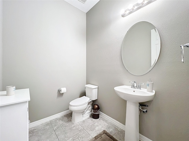 bathroom featuring sink, toilet, and tile patterned flooring