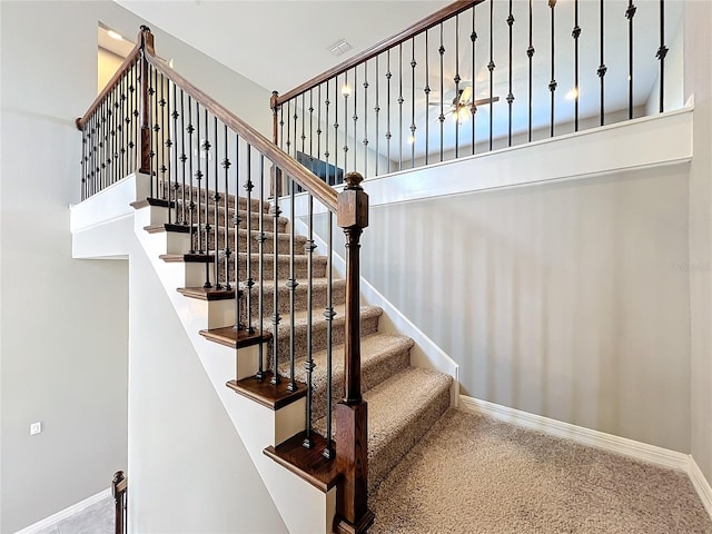 stairway with carpet flooring and a high ceiling