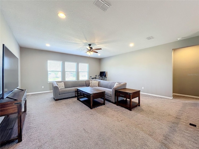 carpeted living room with a textured ceiling and ceiling fan