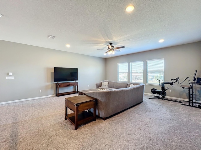 carpeted living room with a textured ceiling and ceiling fan