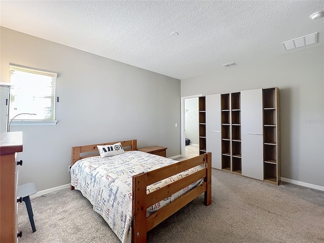 bedroom with a closet, carpet floors, and a textured ceiling