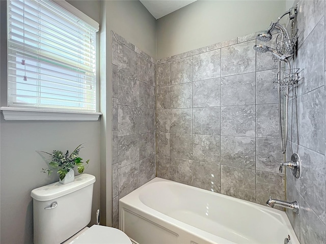 bathroom featuring tiled shower / bath and toilet