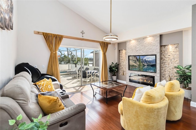 living room featuring dark hardwood / wood-style floors, high vaulted ceiling, and a large fireplace