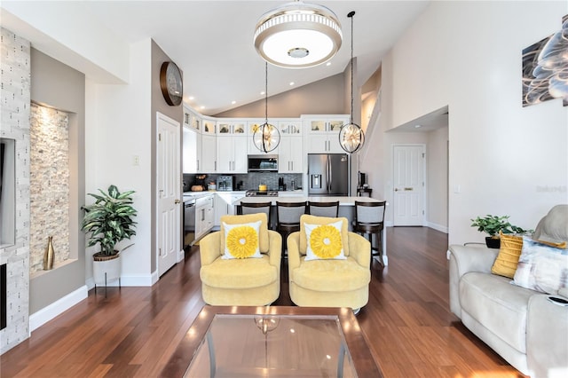 kitchen featuring white cabinetry, hanging light fixtures, appliances with stainless steel finishes, dark hardwood / wood-style floors, and backsplash