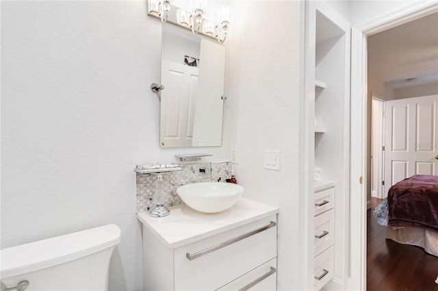 bathroom with tasteful backsplash, vanity, hardwood / wood-style floors, and toilet