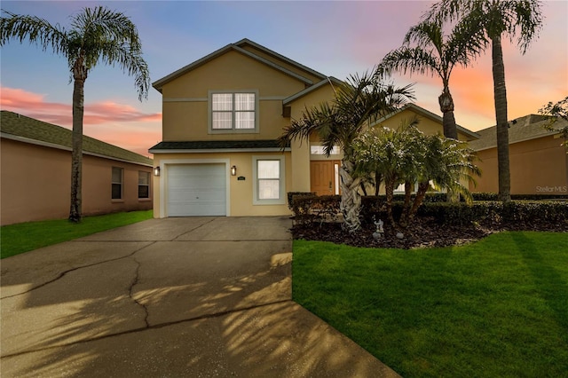 view of front of home with a garage and a lawn