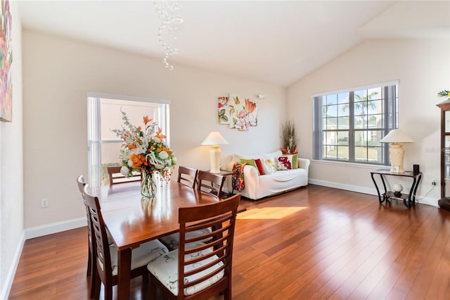 dining space featuring dark wood-type flooring and lofted ceiling