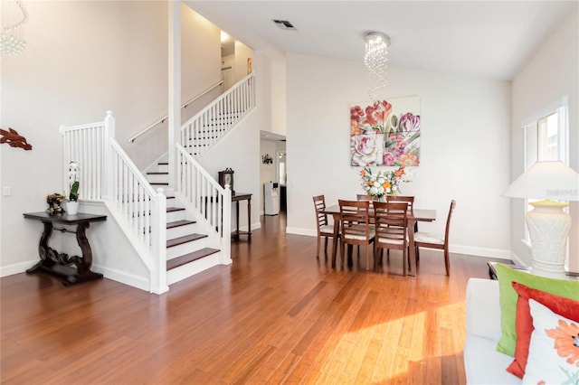 dining room with hardwood / wood-style flooring and high vaulted ceiling