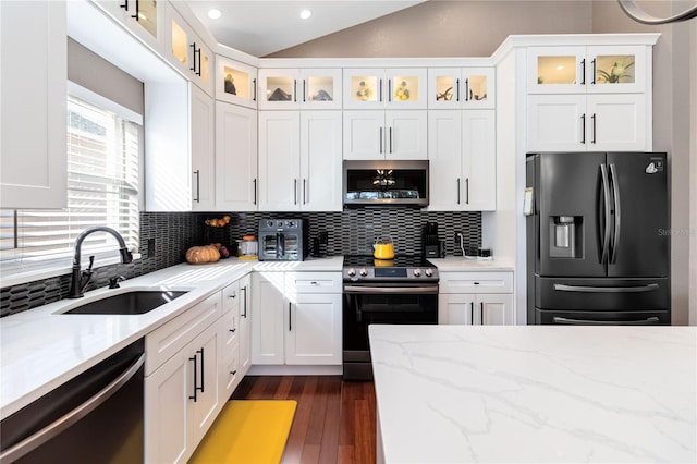 kitchen with stainless steel appliances, light stone countertops, sink, and white cabinets