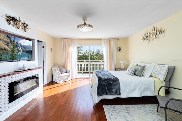 bedroom with access to exterior and hardwood / wood-style flooring