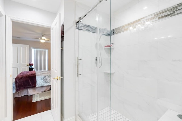 bathroom featuring a shower with door and ceiling fan