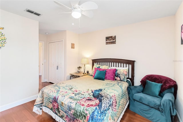 bedroom with wood-type flooring, ceiling fan, and a closet