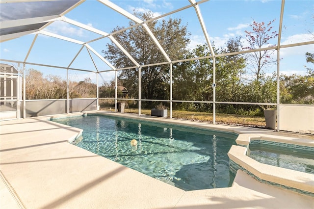 view of pool with a patio area, an in ground hot tub, and glass enclosure