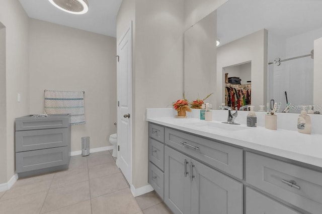 bathroom featuring walk in shower, vanity, toilet, and tile patterned flooring